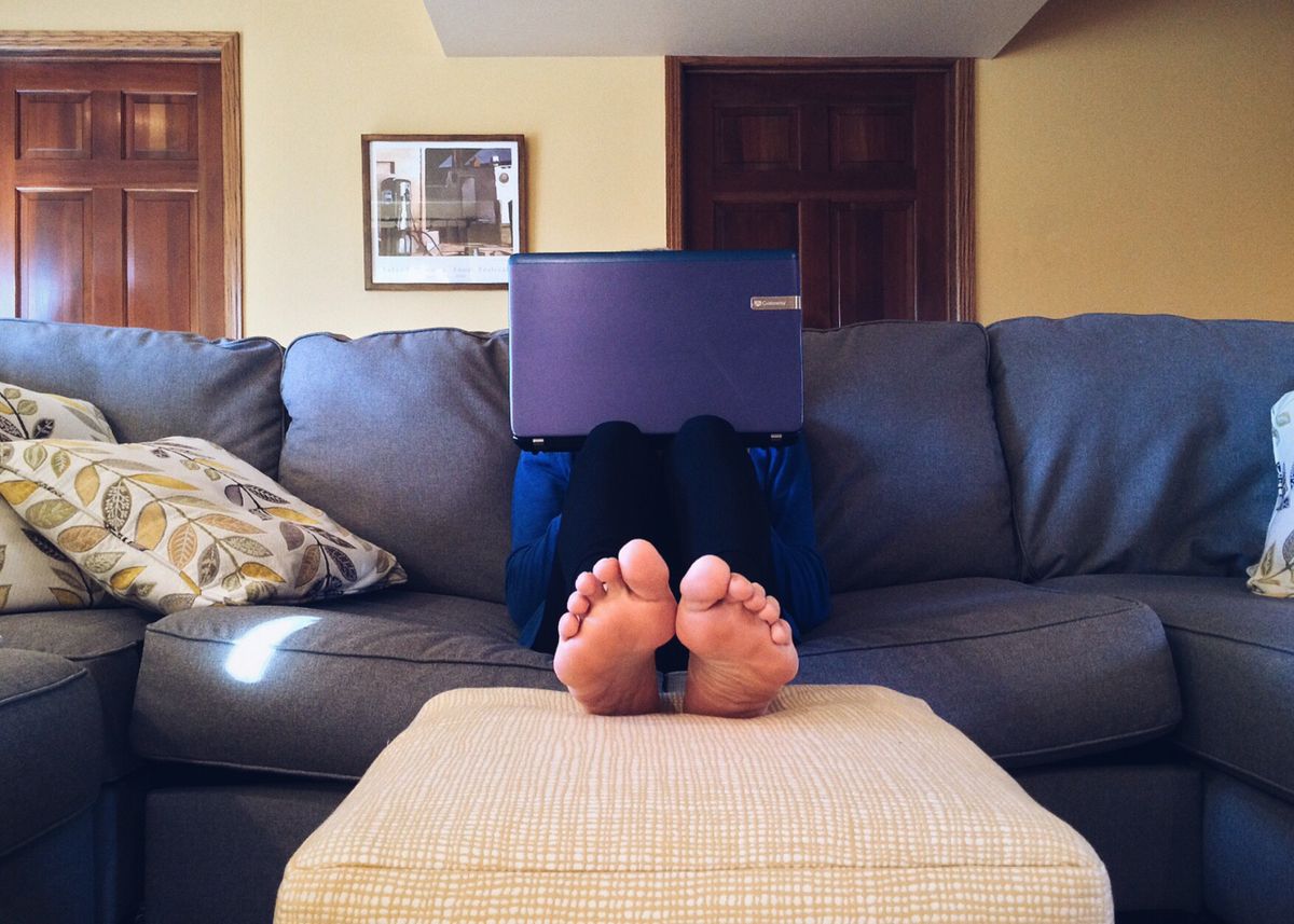 Person relaxing at home while using a laptop